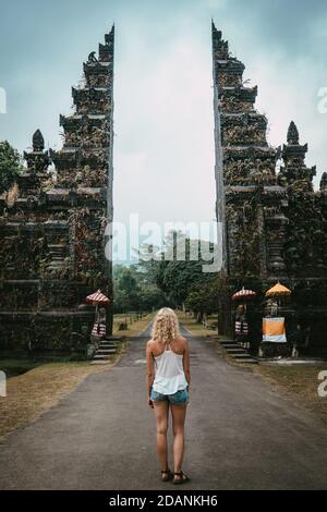 Junge Frau, die vor dem buddhistischen Tor mit Dunkel steht Stimmung Stockfoto