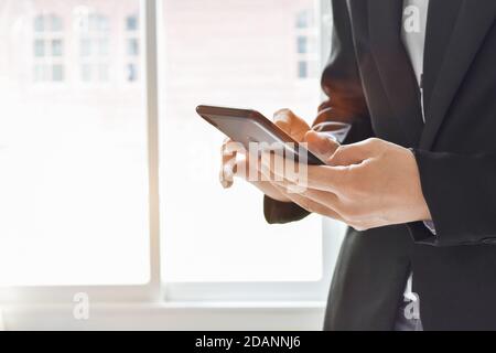 Nahaufnahme eines Geschäftsmannes mit einem Handy. Junge Geschäftsführerin mit Handy. Stockfoto