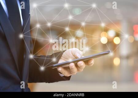 Nahaufnahme von Geschäftsmann mit Smartphone mit Symbol-Netzwerk. Mann Hand hält Handy für Technologie oder Internet-Banking-Konzept. Stockfoto