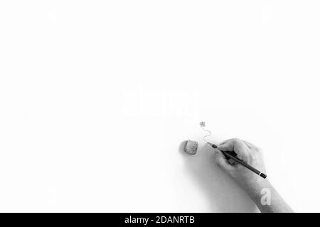Ein minimalistisches, abstraktes Schwarz-Weiß-Porträt einer Hand einer Person, die einen Bleistift hält und unter einem gezeichneten Schmetterling eine wirbelnde Linie zeichnet. Stockfoto