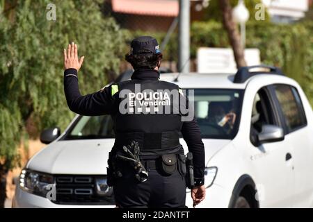 Vendrell, Spanien. März 2020. Ein Polizist hält ein Fahrzeug an einem Kontrollpunkt während der Haftkontrollen an.die örtliche Polizei von El Vendrell führt am Wochenende Haftkontrollen durch, die von der Regierung von Katalonien aufgrund der Gesundheitskrise von Covid-19 erlassen wurden. Menschen von Freitag um 0600 Uhr bis Montag um 6:00 Uhr können ihre Wohngemeinde nicht verlassen, außer für einige begrenzte Ausnahmen. Quelle: Ramon Costa/SOPA Images/ZUMA Wire/Alamy Live News Stockfoto