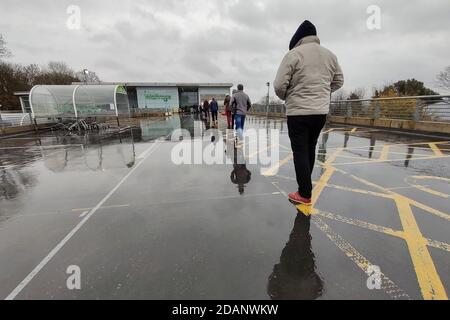 Rickmansworth, Großbritannien. 14. November 2020. Die Einkäufer stehen im Regen und bilden eine sozial distanzierte Linie, während sie warten, um den Waitrose-Supermarkt in Rickmansworth, Hertfordshire, während Englands zweites Wochenende einer zweiten Sperre, die von der britischen Regierung verhängt wurde, zu betreten. Die Sperre soll bis zum 2. Dezember laufen, da die Regierung versucht, die laufende Coronavirus-Pandemie zu kontrollieren. Kredit: Stephen Chung / Alamy Live Nachrichten Stockfoto