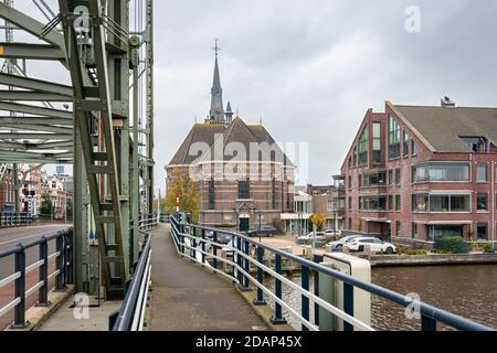 Evangelische Kirche im Dorf Boskoop, Niederlande. Ein Fußweg entlang einer Brücke führt zur Kirche. Stockfoto