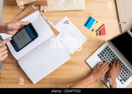 Blick auf die Hände junger Managerinnen, die Online-Zahlungen erhalten Der Kunden Stockfoto