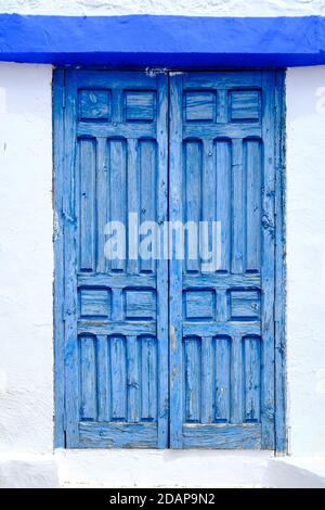 Verwittertes blaues Holz Vintage Bauernhaus Fenster an weißer Wand Stockfoto