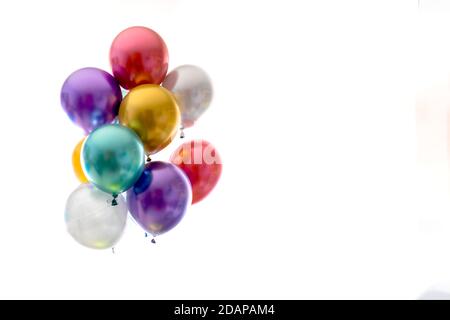 Heliumballons in Metallic-Farben auf weißem Hintergrund Stockfoto