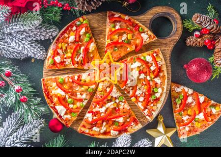 Weihnachtlich geschmückte Pizza. Set aus verschiedenen hausgemachten Pizza mit Weihnachtsdekoration - Cheesy Schneeflocken, Weihnachtsbaum Scheiben und Pepperoni Sterne, mit dez Stockfoto