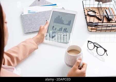 Hände von jungen Geschäftsfrau oder Bankier mit Tablet Analyse Graph Und Diagramme Stockfoto