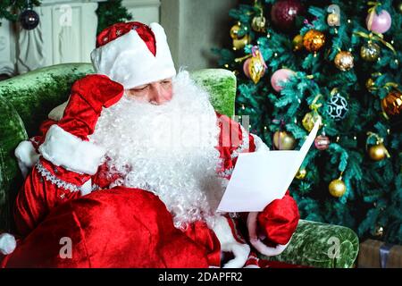 Porträt des Weihnachtsmannes beim Lesen von Weihnachtsbriefen Stockfoto