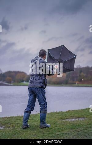 Kidderminster, Großbritannien. November 2020. Wetter in Großbritannien: Sehr nasser und windiger Wind weht die Wanderer am Trimpley Stausee weg. Die Menschen kämpfen darum, ihre Schirme nicht von innen nach außen zu drehen. Kredit: Lee Hudson/Alamy Live Nachrichten Stockfoto