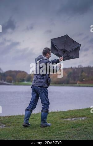 Kidderminster, Großbritannien. November 2020. Wetter in Großbritannien: Sehr nasser und windiger Wind weht die Wanderer am Trimpley Stausee weg. Die Menschen kämpfen darum, ihre Schirme nicht von innen nach außen zu drehen. Kredit: Lee Hudson/Alamy Live Nachrichten Stockfoto