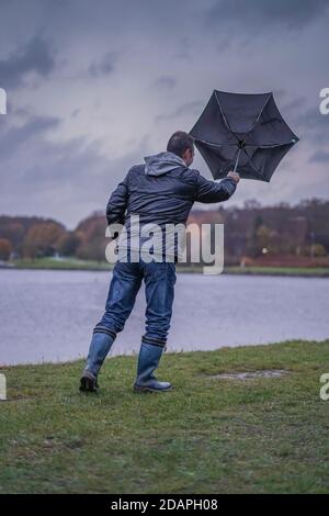 Kidderminster, Großbritannien. November 2020. Wetter in Großbritannien: Sehr nasser und windiger Wind weht die Wanderer am Trimpley Stausee weg. Die Menschen kämpfen darum, ihre Schirme nicht von innen nach außen zu drehen. Kredit: Lee Hudson/Alamy Live Nachrichten Stockfoto