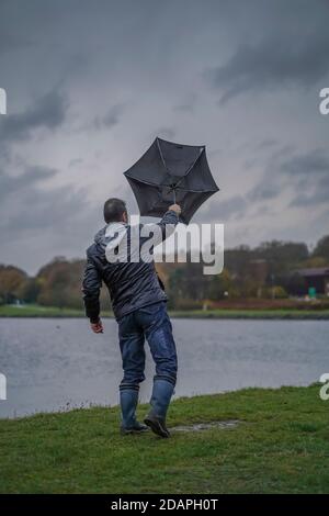 Kidderminster, Großbritannien. November 2020. Wetter in Großbritannien: Sehr nasser und windiger Wind weht die Wanderer am Trimpley Stausee weg. Die Menschen kämpfen darum, ihre Schirme nicht von innen nach außen zu drehen. Kredit: Lee Hudson/Alamy Live Nachrichten Stockfoto