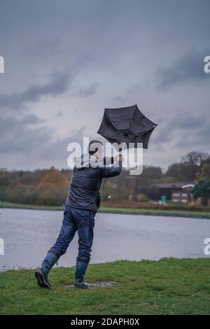 Kidderminster, Großbritannien. November 2020. Wetter in Großbritannien: Sehr nasser und windiger Wind weht die Wanderer am Trimpley Stausee weg. Die Menschen kämpfen darum, ihre Schirme nicht von innen nach außen zu drehen. Kredit: Lee Hudson/Alamy Live Nachrichten Stockfoto