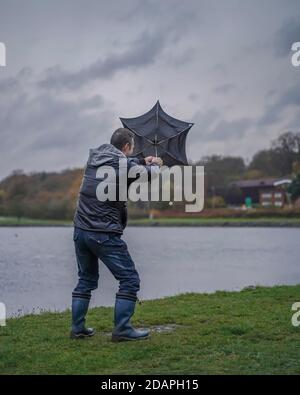 Kidderminster, Großbritannien. November 2020. Wetter in Großbritannien: Sehr nasser und windiger Wind weht die Wanderer am Trimpley Stausee weg. Die Menschen kämpfen darum, ihre Schirme nicht von innen nach außen zu drehen. Kredit: Lee Hudson/Alamy Live Nachrichten Stockfoto