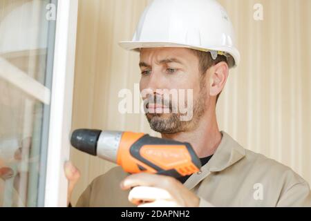 Unsicherer Mann bohrt Löcher Stockfoto