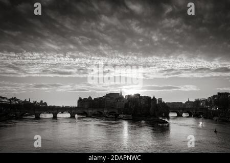 Pariser Sonnenaufgang über der Ile de la Cite und dem Ufer der seine (UNESCO-Weltkulturerbe) mit Pont Neuf in Schwarz-Weiß. Frankreich Stockfoto