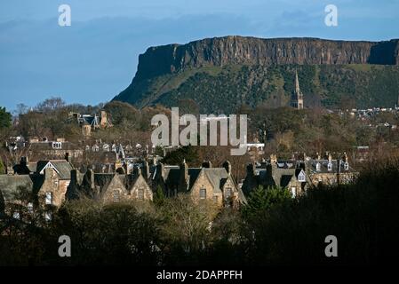 Wohnhäuser in Süd-Edinburgh mit Salisbury Crags im Hintergrund, aufgenommen aus Blackford Hill, Edinburgh, Schottland, Großbritannien. Stockfoto