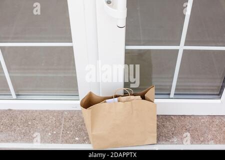 Paket-Karton in der Vordertür.Tür zu Tür Lieferung von guten Merchandise, während die Quarantäne, geliefert außerhalb der Tür, E-Commerce-Kauf Stockfoto