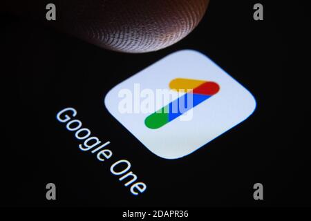 Stafford / Vereinigtes Königreich - November 12 2020: Google One App und verschwommene Fingerspitze darüber bereit, den Bildschirm des Smartphones drücken. Der Cloud-Speicher Stockfoto