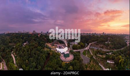 Panoramablick auf Kiew vom Himmel. Sonnenuntergang über Sommer Kiew mit Bogen der Freundschaft der Völker. Gefilmt auf Drohne. Luftaufnahme Stockfoto