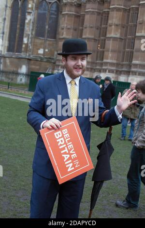 GROSSBRITANNIEN / England / London / Morrris aus Oxford Ein Engländer mit Melone Hut hält ein Plakat mit der Aufschrift "Glauben In Großbritannien“ vor den Häusern Stockfoto