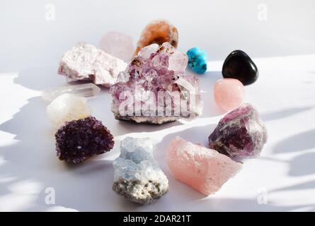 Edelsteine liegen auf dem Tisch. Amethyst, Rosenquarz, Türkis, Citrin, Fluorit und andere Mineralien Stockfoto