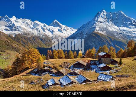 Almhütten im Val d'Herens, dahinter verschneite Walliser Alpen, Kanton Wallis, Schweiz Stockfoto