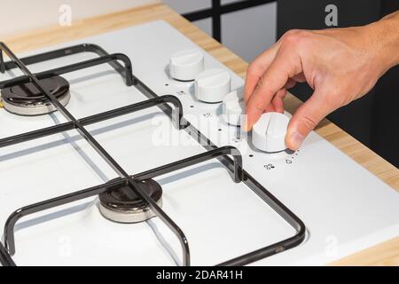 Die Hand eines Mannes schaltet den Gasherd an Stockfoto