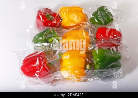 Rote, gelbe und grüne Paprika (Capsicum annuum) aus dem Supermarkt in Plastik eingewickelt, Gemüse in Verpackungen aus Kunststoff, Kunststoff Stockfoto