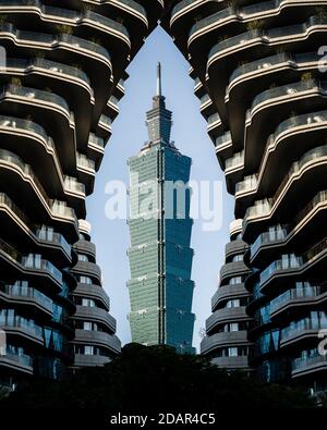 Blick auf den Taipei 101 Tower, umrahmt von einem Hochhaus, Taipei, Taiwan Stockfoto