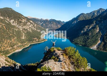 Wanderer streckt die Arme in die Luft, Blick auf Plansee, Schoenjoechl im Hintergrund, Wanderung nach Schrofennas, Ammergauer Alpen, Landkreis Reutte, Tirol Stockfoto