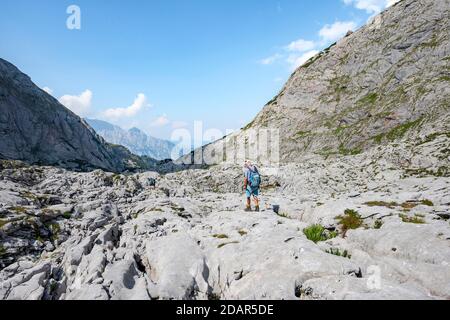 Wanderer in einer Landschaft aus verwaschenen Karstfelsen, Funtenseetauern, Steinernes Meer, Nationalpark Berchtesgaden, Berchtesgadener Land, Oberbayern Stockfoto