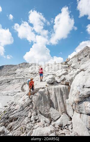 Zwei Wanderer in einer Landschaft aus verwaschenen Karstfelsen, Funtenseetauern, Steinernes Meer, Nationalpark Berchtesgaden, Berchtesgadener Land, Obere Stockfoto