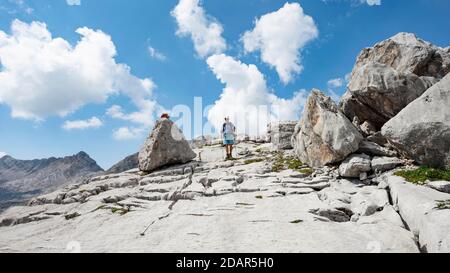 Wanderer in einer Landschaft aus verwaschenen Karstfelsen, Funtenseetauern, Steinernes Meer, Nationalpark Berchtesgaden, Berchtesgadener Land, Oberbayern Stockfoto