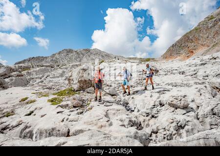 Drei Wanderer in einer Landschaft aus verwaschenen Karstfelsen, Funtenseetauern, Steinernes Meer, Nationalpark Berchtesgaden, Berchtesgadener Land, Obere Stockfoto