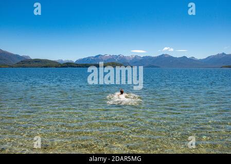 Der junge Mann badet im See, Lake Manapouri, Fraser Beach, Manapouri, South Island, Neuseeland Stockfoto