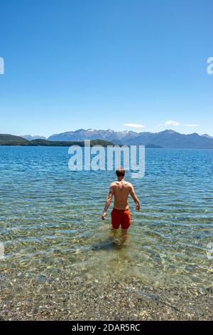 Der junge Mann badet im See, Lake Manapouri, Fraser Beach, Manapouri, South Island, Neuseeland Stockfoto