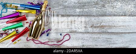 Happy New Year Konzept mit einer goldenen Flasche Champagner, Trinkgläsern und Party Dekorationen Stockfoto