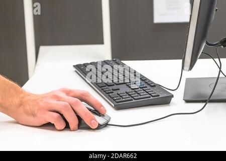 Die Hand eines Mannes auf einer Computermaus Stockfoto