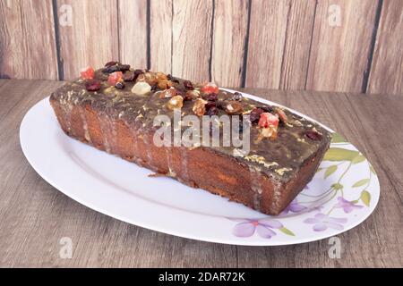 Hausgemachter Zitronenpudding auf einer weißen Platte mit Vintage-Stil Blume Zeichnungen auf einem Holztisch und rustikalem Nut-Feder-Hintergrund Stockfoto