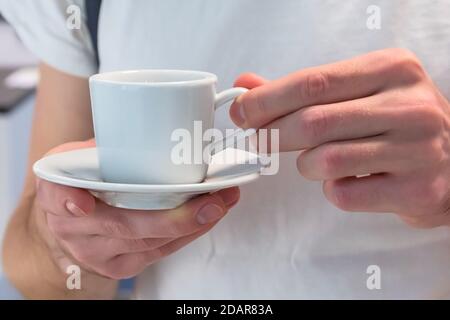 Weiße Kaffeetasse in Herrenhänden Stockfoto