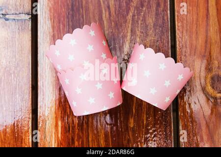 Leere Papierformen zum Backen von Muffins, rosa Muffins in weißen Tupfen Stockfoto