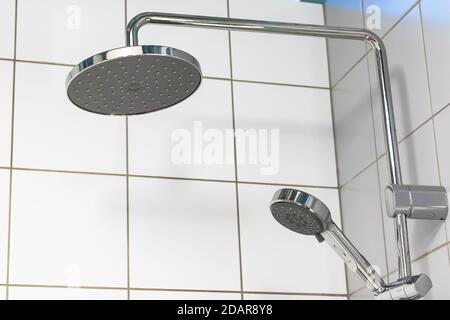 Duschkopf auf weißem Fliesenhintergrund Stockfoto