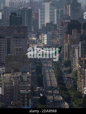 Uni Air Flugzeug fliegt über Stadtgebiet mit Straßen und Wolkenkratzern, Taipei, Taiwan Stockfoto