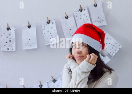 Erster Adventssonntag. Mädchen in einem Weihnachtshut. Der Advent beginnt - Träume werden wahr Stockfoto