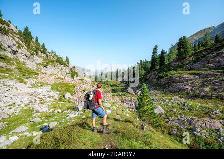 Wanderer blickt in die Ferne, im Hintergrund der Gipfel des Watzmann, Wanderweg in den Funtenseetauern, Steinernes Meer, Berchtesgaden National Stockfoto