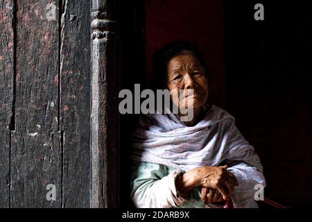 Porträt einer älteren Frau, die aus einer Tür schaut, Patan, Lalitpur, Kathmandu, Nepal