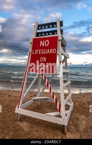 Rettungsschwimmer stehen ohne Rettungsschwimmer im Dienst, da die Sonne auf dem Lake Michigan untergeht. Lighthouse Beach, Evanston, Illinois Stockfoto