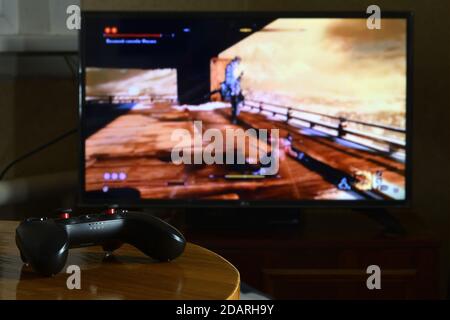 KHARKOV, UKRAINE - 12. NOVEMBER 2020: Videospiel-Controller Gamesir g3s auf dem Tisch mit Sekiro Shadows sterben zweimal Spiel auf großem Display Stockfoto